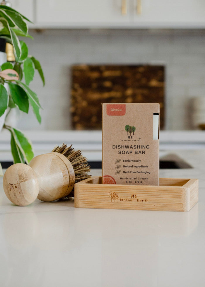 Dishwashing soap bar with packaging and brushes on a kitchen counter