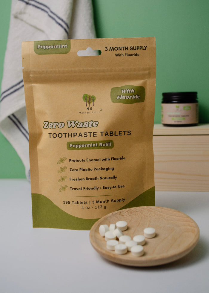 Zero Waste Toothpaste Tablets packaging with tablets on a wooden plate against a green background
